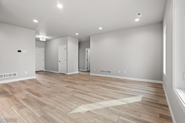 empty room with light wood-type flooring and visible vents