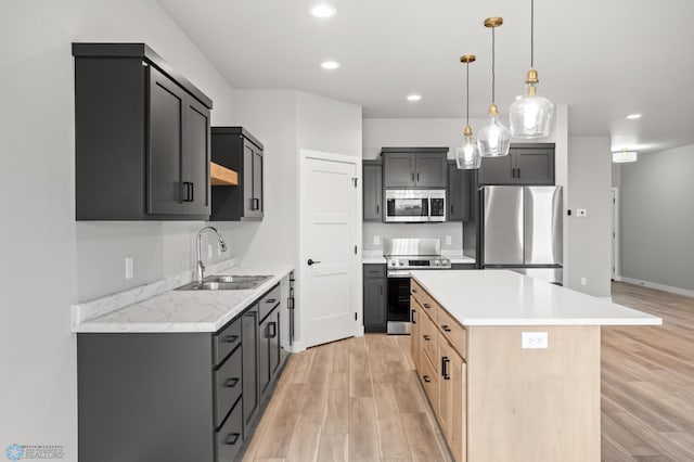 kitchen featuring stainless steel appliances, light wood-style floors, light countertops, and a sink