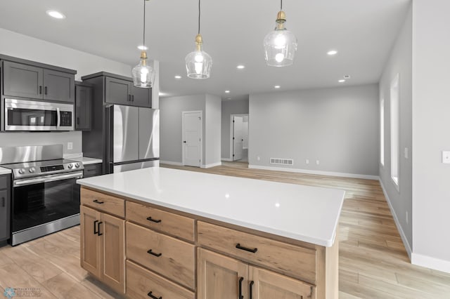 kitchen featuring visible vents, light countertops, appliances with stainless steel finishes, brown cabinetry, and decorative light fixtures