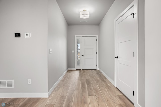 entrance foyer featuring light wood-style floors, visible vents, and baseboards