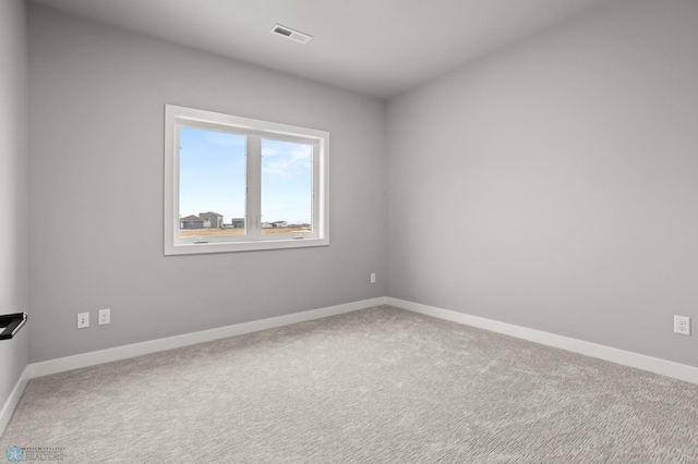 unfurnished room featuring carpet, visible vents, and baseboards