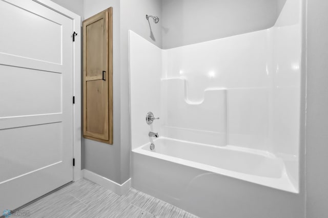 full bathroom with shower / bath combination and baseboards