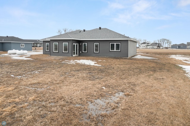 rear view of property with a shingled roof