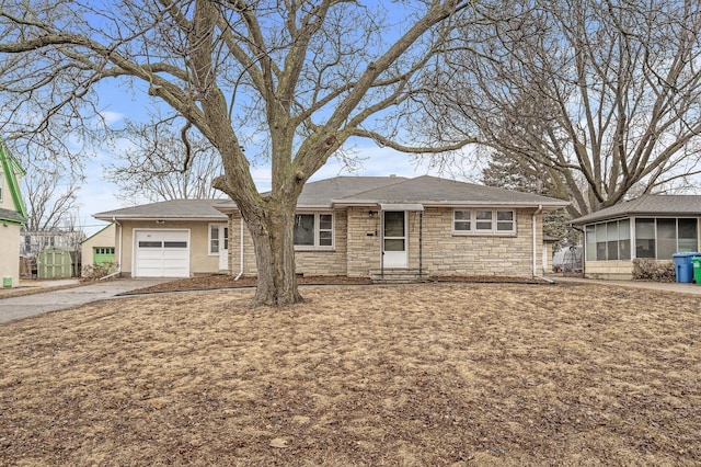 ranch-style home featuring a garage, driveway, stone siding, and a sunroom