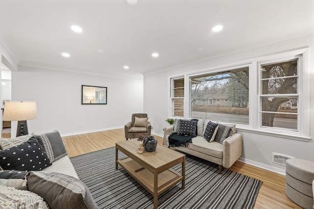 living area featuring baseboards, light wood-style flooring, and recessed lighting