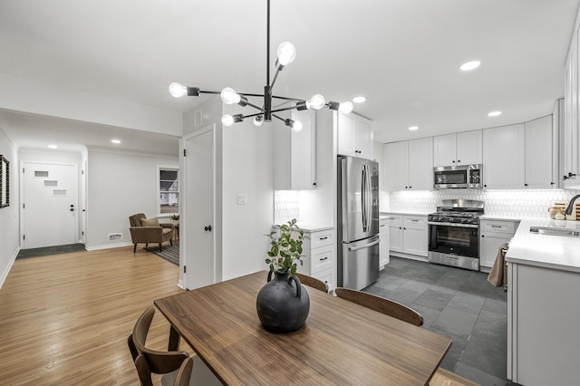 dining room with recessed lighting, a notable chandelier, and wood finished floors