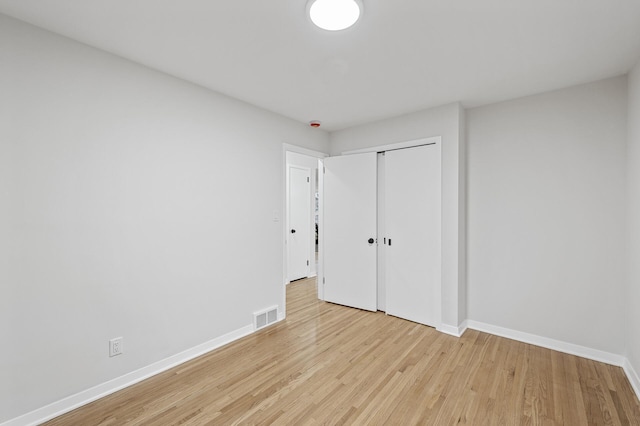 unfurnished bedroom featuring light wood finished floors, baseboards, and visible vents