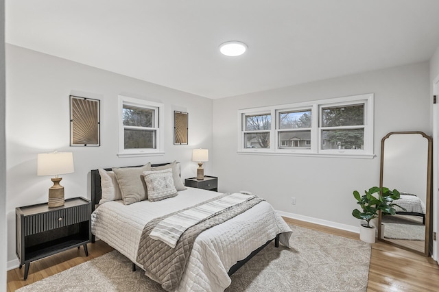 bedroom with wood finished floors and baseboards