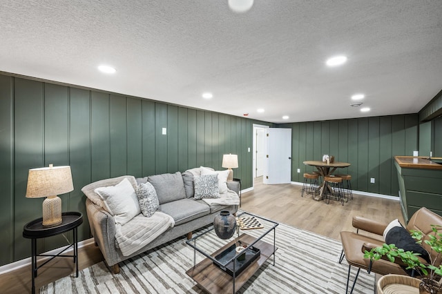 living room featuring a textured ceiling, wood finished floors, and recessed lighting