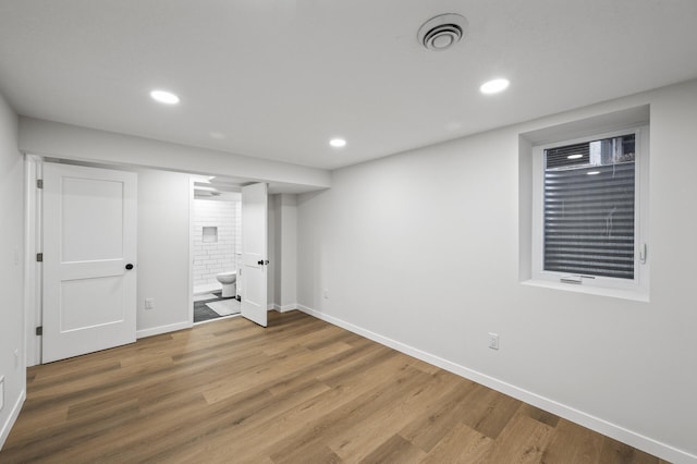 finished below grade area with recessed lighting, visible vents, baseboards, and wood finished floors