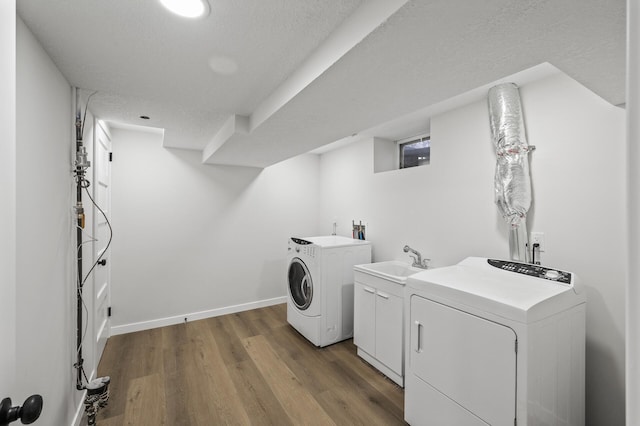 laundry room with separate washer and dryer, a sink, wood finished floors, baseboards, and cabinet space