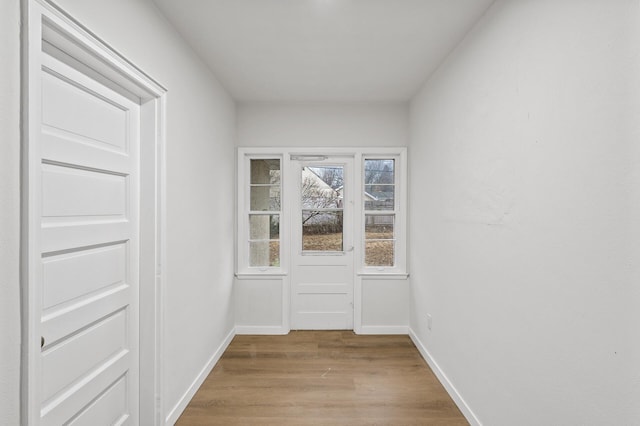 doorway to outside featuring wood finished floors and baseboards