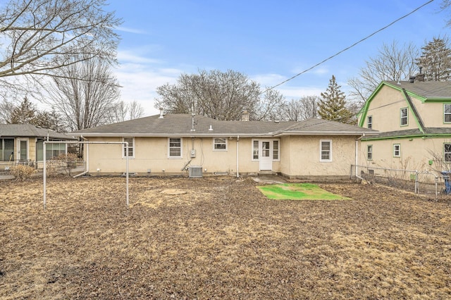 rear view of property with central AC, a chimney, fence, and stucco siding