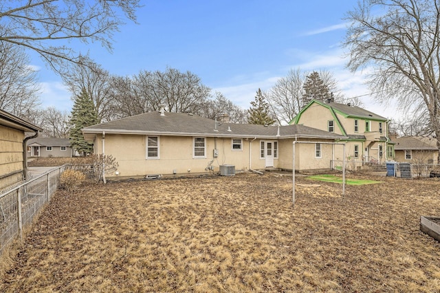 back of property with central AC unit, a chimney, and fence