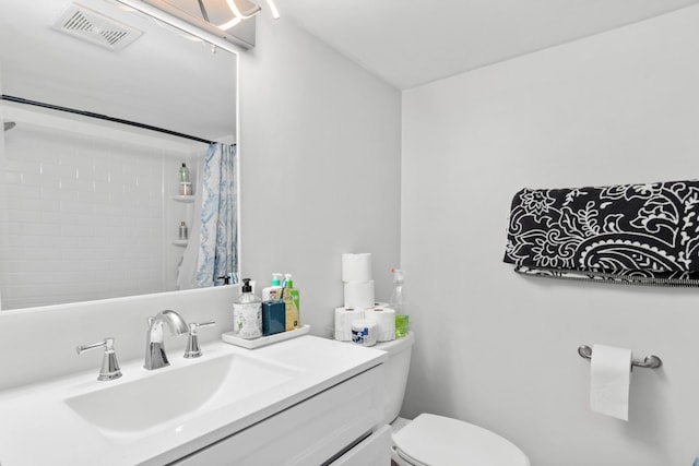 bathroom featuring a shower with curtain, visible vents, vanity, and toilet