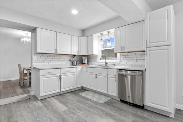 kitchen with dishwasher, a sink, a textured ceiling, light countertops, and white cabinetry
