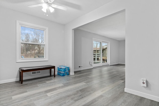spare room featuring ceiling fan, baseboards, and wood finished floors