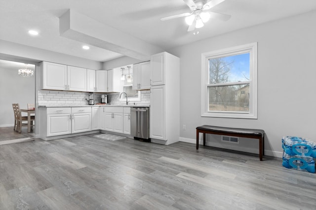 kitchen featuring stainless steel dishwasher, baseboards, light countertops, decorative backsplash, and recessed lighting