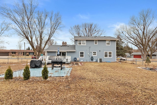 rear view of property featuring fence, central air condition unit, a deck, and a chimney