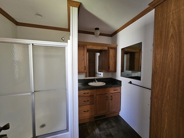 bathroom featuring ornamental molding, a stall shower, wood finished floors, and vanity