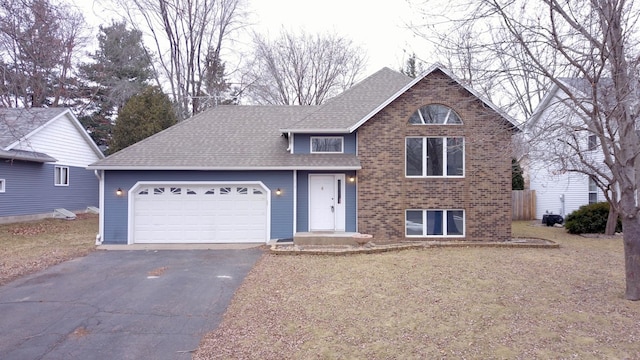 view of front of property with driveway, brick siding, roof with shingles, and an attached garage