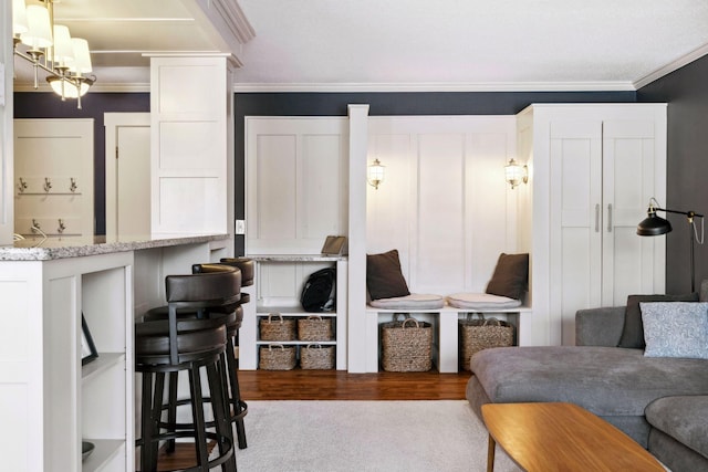 living area with dark wood-style floors and ornamental molding