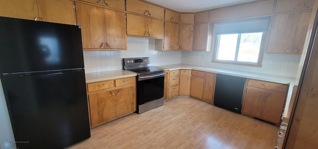 kitchen with black appliances, light countertops, light wood finished floors, and brown cabinetry