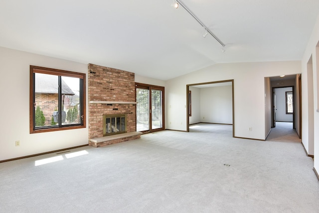 1021 Yuma Ln N, Plymouth, MN 55447 - unfurnished living room featuring rail lighting, vaulted ceiling, light carpet, and a brick fireplace
