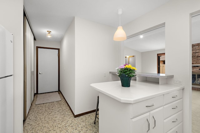 1021 Yuma Ln N, Plymouth, MN 55447 - kitchen with freestanding refrigerator, white cabinets, light countertops, a kitchen breakfast bar, and pendant lighting