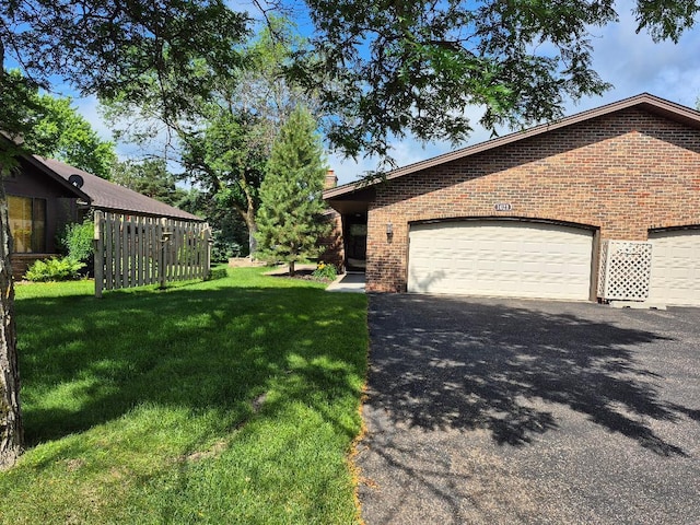 1021 Yuma Ln N, Plymouth, MN 55447 - view of front of property featuring brick siding, asphalt driveway, a front yard, an attached garage, and a chimney