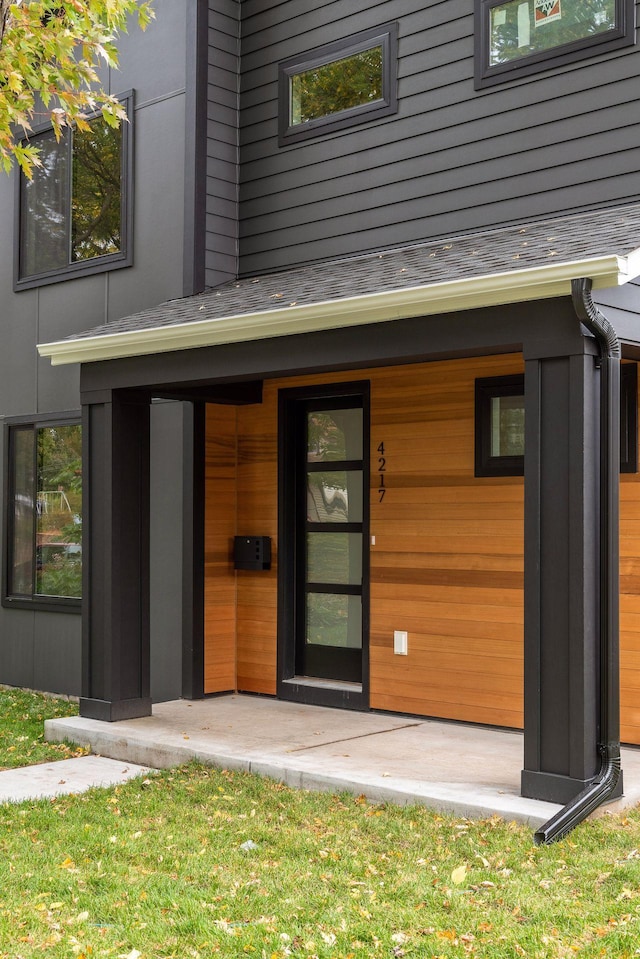 doorway to property featuring a shingled roof