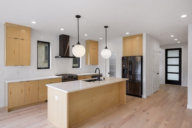 kitchen with wall chimney exhaust hood, light brown cabinetry, a sink, and black fridge with ice dispenser