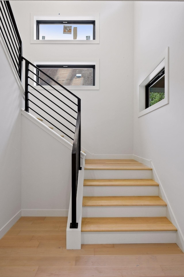 stairway with wood finished floors and baseboards