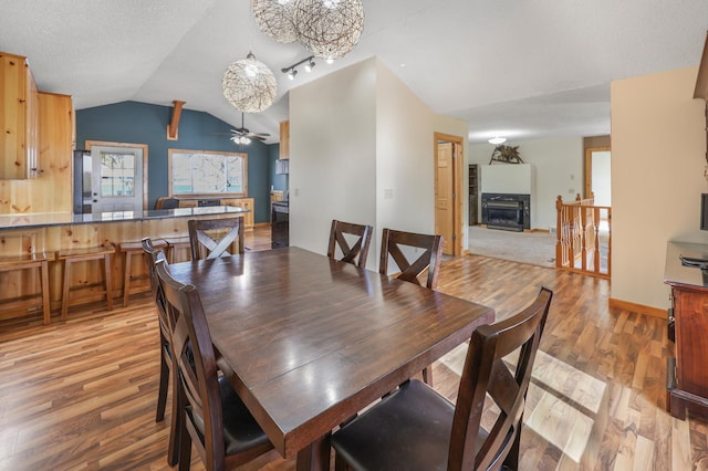 dining room with ceiling fan, light wood-type flooring, and lofted ceiling