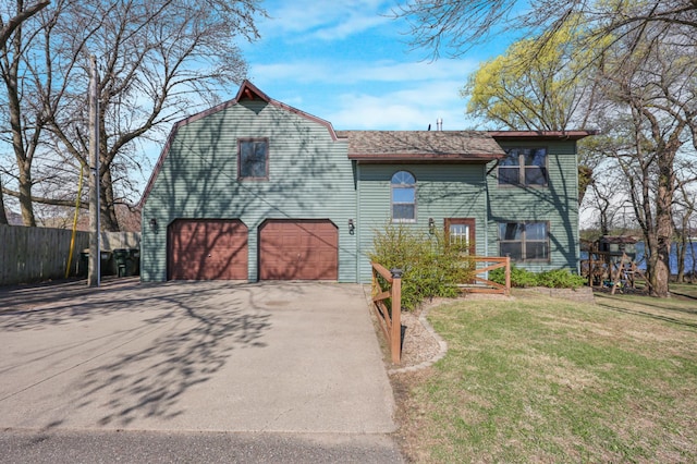view of front of property featuring a front lawn, aphalt driveway, fence, roof with shingles, and an attached garage