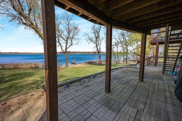 view of patio with stairs and a deck with water view