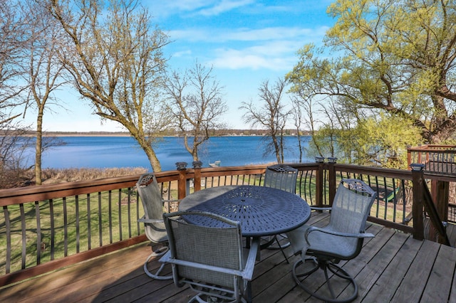 wooden deck with a water view and outdoor dining space