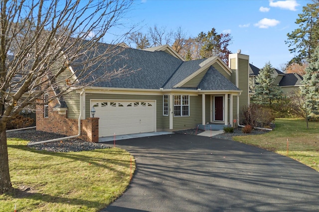 view of front of home with a garage, driveway, a shingled roof, and a front yard