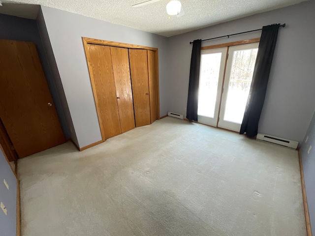 unfurnished bedroom with a baseboard radiator, a closet, light colored carpet, baseboard heating, and a textured ceiling