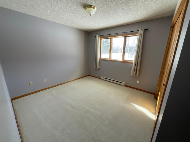 empty room with a baseboard radiator, light carpet, a textured ceiling, and baseboards