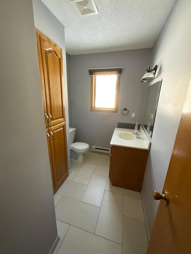 half bathroom featuring tile patterned flooring, toilet, a baseboard heating unit, vanity, and visible vents