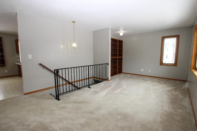 carpeted empty room featuring baseboards