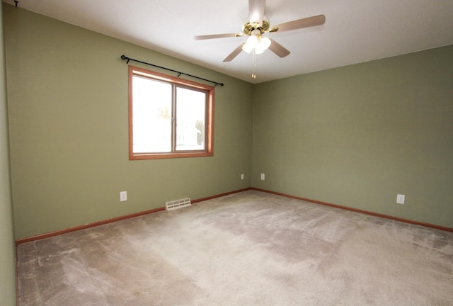 unfurnished room with light carpet, baseboards, visible vents, and ceiling fan