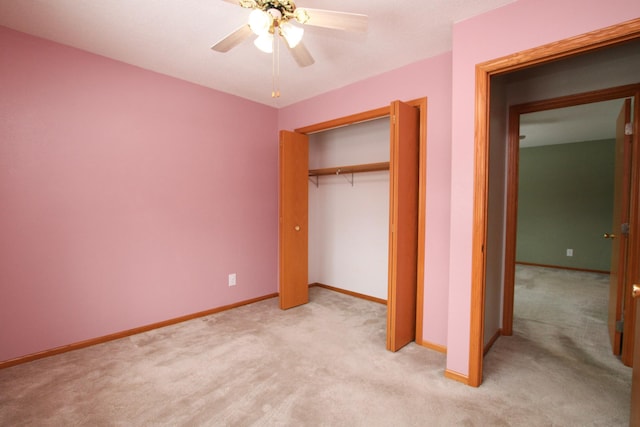 unfurnished bedroom featuring baseboards, ceiling fan, a closet, and light colored carpet