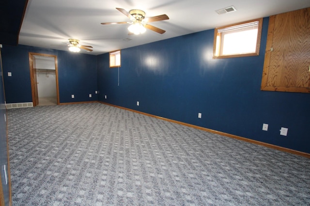 below grade area with a ceiling fan, carpet, visible vents, and baseboards