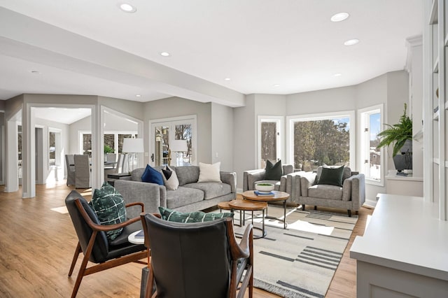 living area featuring baseboards, recessed lighting, and light wood-style floors