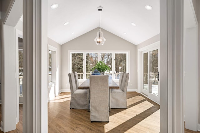 dining room with lofted ceiling, baseboards, wood finished floors, and recessed lighting