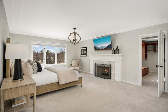 bedroom with baseboards, an inviting chandelier, a spacious closet, carpet flooring, and a fireplace