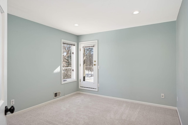 carpeted spare room featuring recessed lighting, visible vents, and baseboards