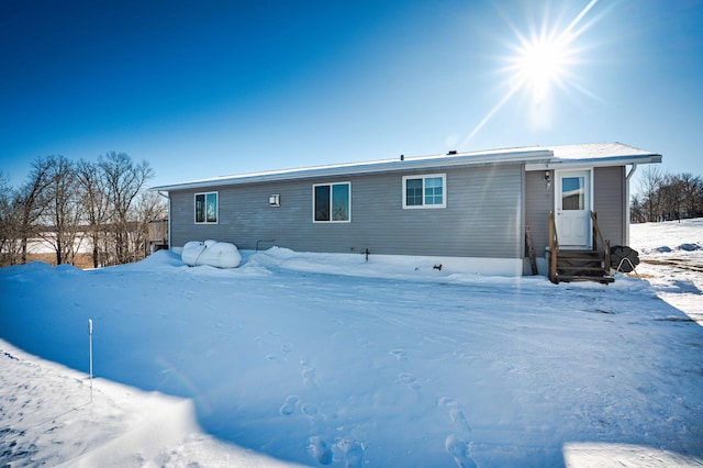 view of snow covered back of property